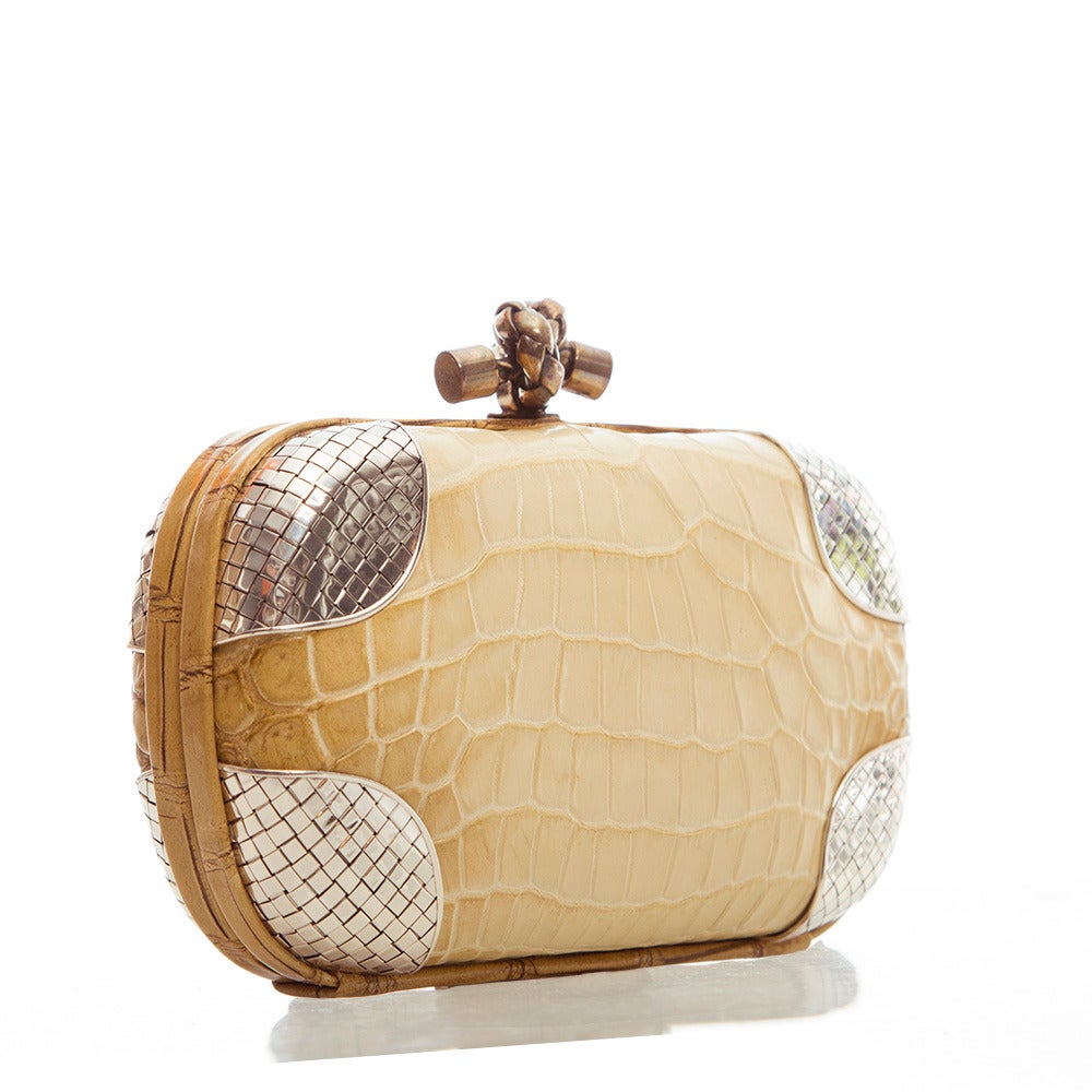 This alluring clutch from Bottega Veneta features a croc leather body, textured metal hardware at corners and a logo detail clasp. The contrast lining is crafted in pure suede.

Material: Crocodile leather

Colour: Beige
Condition: 9 out of