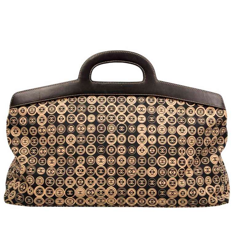 Channel a sense of laid-back chic with this beautiful black and tan fabric patterned large holdall from Chanel featuring iconic CC logo print, leather handles and snap closure. Interior features black fabric lining and one pocket.

Colour: Black,