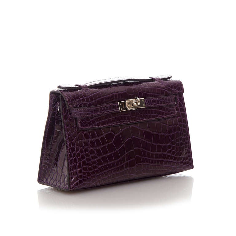 This Hermes Kelly Pochette is made from crocodile leather in an amazing amethyst tone. Boasting an interior lined in leather with one patch pocket, a top handle, the traditional palladium twist-lock fastening and metal feet.

Material: Crocodile