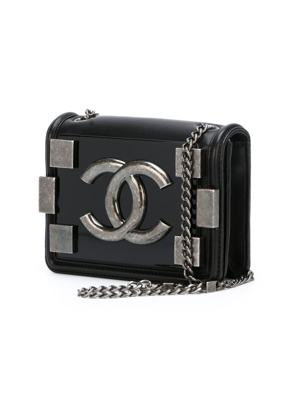 This black lambskin 'Boy Brick' flap crossbody bag from Chanel features a front flap closure, a silver-tone logo plaque, silver-tone hardware, a chain and leather strap, an internal slip pocket, an internal logo patch and a quilted back