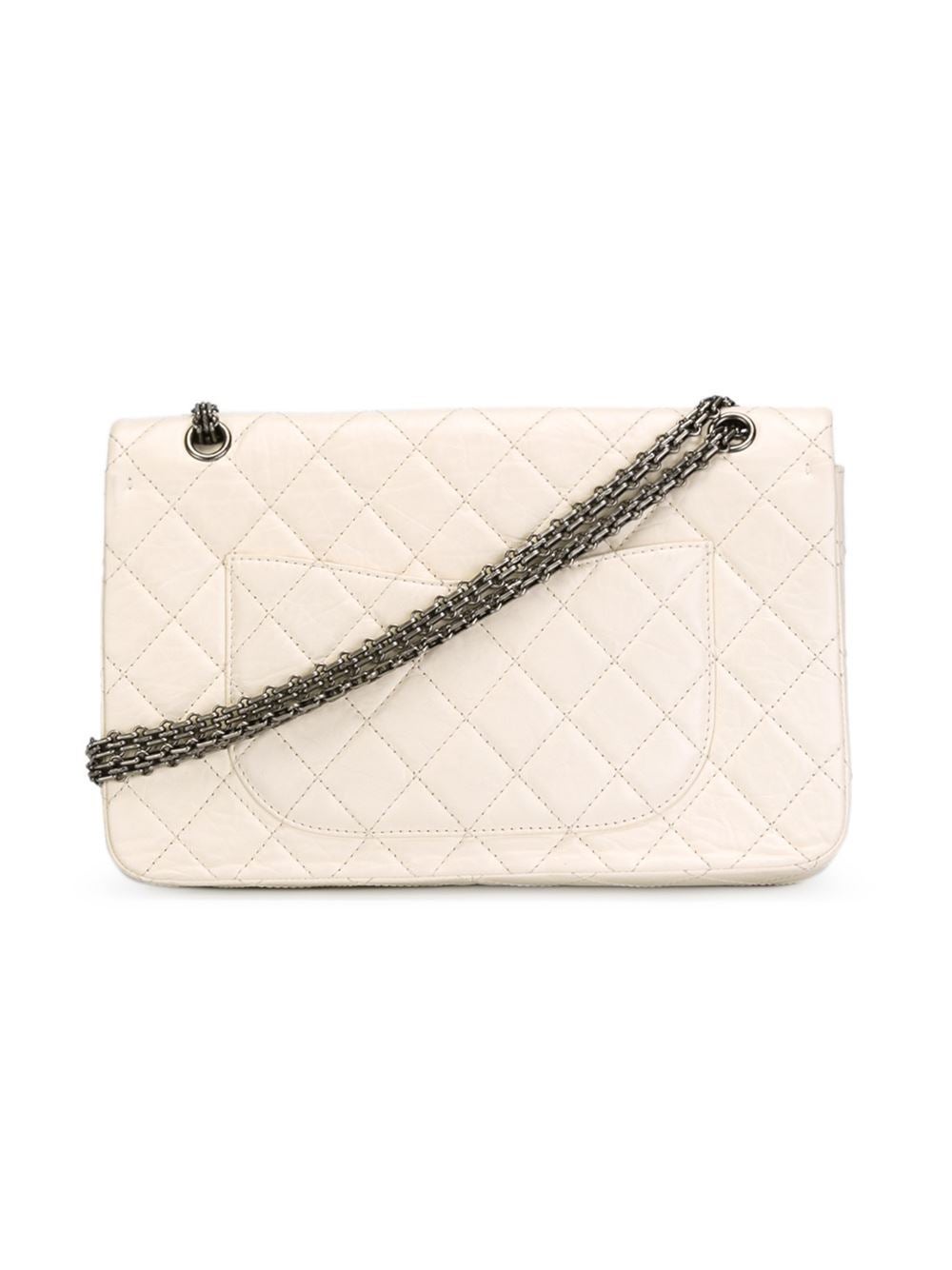 This white calf leather reissue flap shoulder bag from Chanel features fold-over top with twist-lock closure, a quilted effect, a silver-tone chain shoulder strap, a back slip pocket, an internal logo stamp, multiple interior compartments, an
