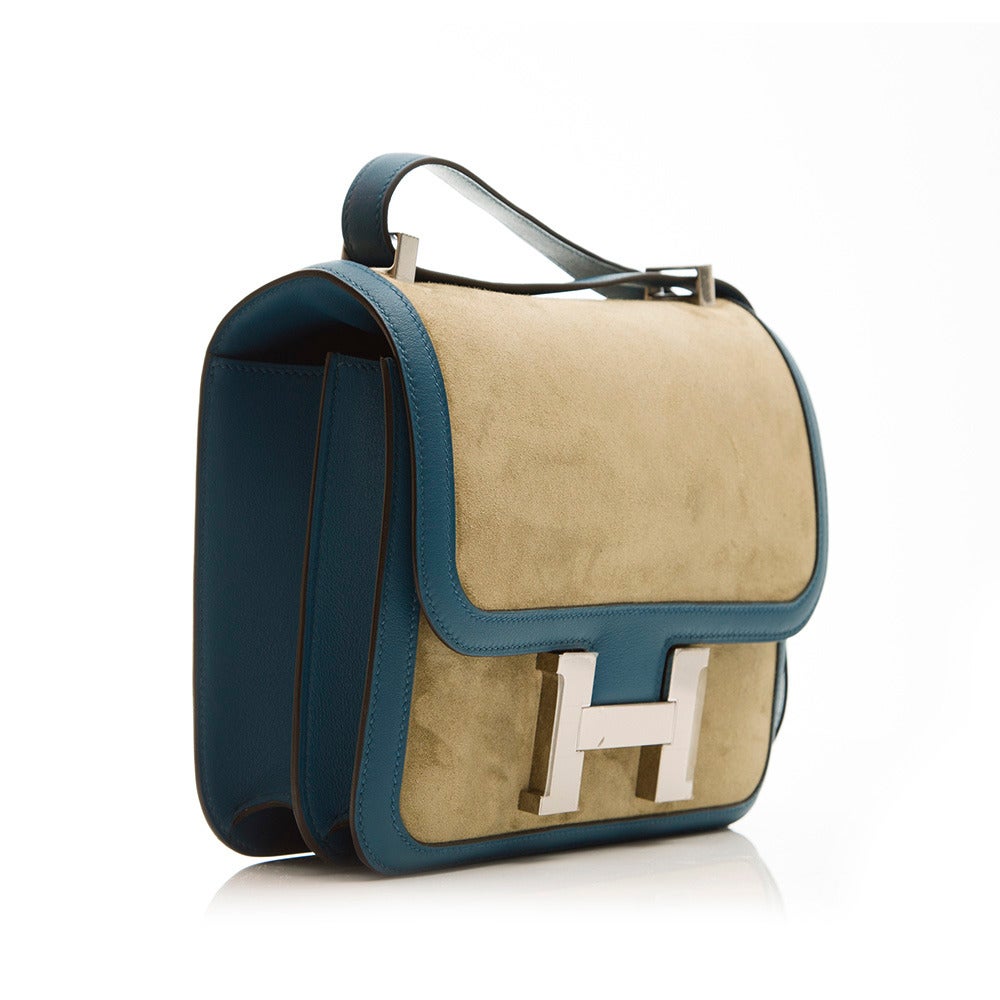 A classic style with a contemporary flare makes this Constance from Hermès even more desirable. Featuring a charming two-tone suede leather, this piece also sports silver hardware on the face and shoulders, a generous shoulder strap, two internal