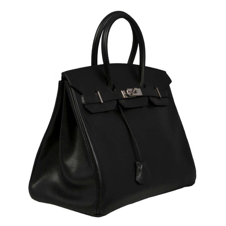 This 35cm Birkin bag is crafted in black epsom leather leather and is accented with the brand's signature palladium hardware. Its interior boasts two pockets - one zipped, the other open and the bag comes with the original lock and key, dust bag,