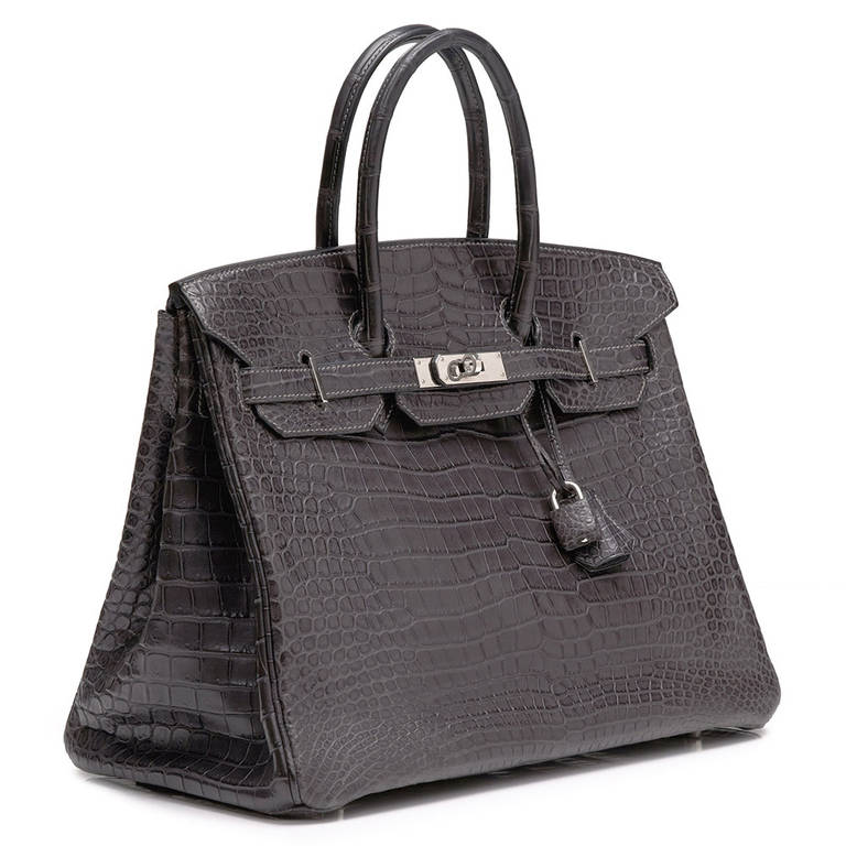 This 35cm Birkin is crafted in Grey Graphite Crocodile Leather and is accented with the brand’s signature palladium hardware. Its interior boasts 2 pockets one zipped and the other open. The bag comes with the original lock and key, care booklet and