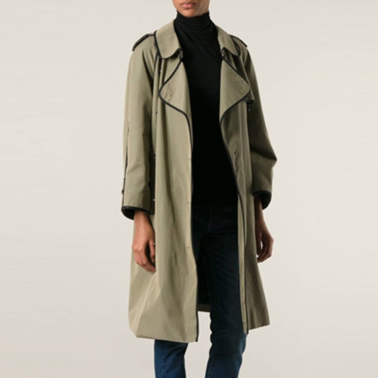 Khaki and black cotton double breasted trench coat from Chanel Vintage featuring epaulettes on the shoulders, notched lapels, a belted waist, front pockets, a storm flap and button cuffs.

Colour:Green, Black

Material: Outer: Cotton, wool