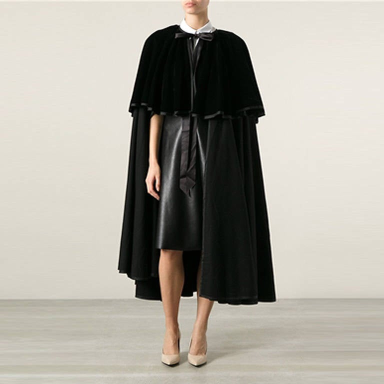 Yves Saint Laurent Layered Velvet Cloak. 	
Black wool and silk cloak from Yves Saint Laurent Vintage featuring a round neck, a ribbon fastening and a layered design.

Colour: Back

Material: Velvet, wool

Measurements: W: cm H: cm D: cm