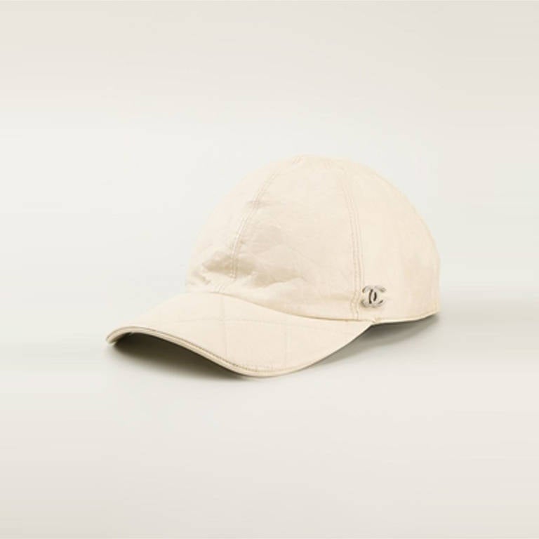 Chanel Vintage Baseball Cap. Chanel Vintage Beige leather baseball cap, featuring a silver-tone logo plaque and a quilted brim.

Colour: Cream
Material: Leather
Measurements: circumference: 57cm brim: 7cm

8 out of 10, good condition.