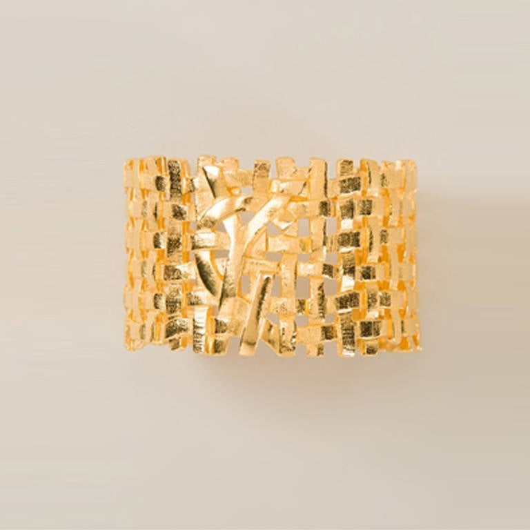 Yves Saint Laurent Vintage Woven Logo Cuff.  	
Gold plated metal cuff from Yves Saint Laurent Vintage featuring a woven effect and logo at the front.

Colour: Gold

Material: Gold- plated metal
Measurements: width: 4 centimetres,