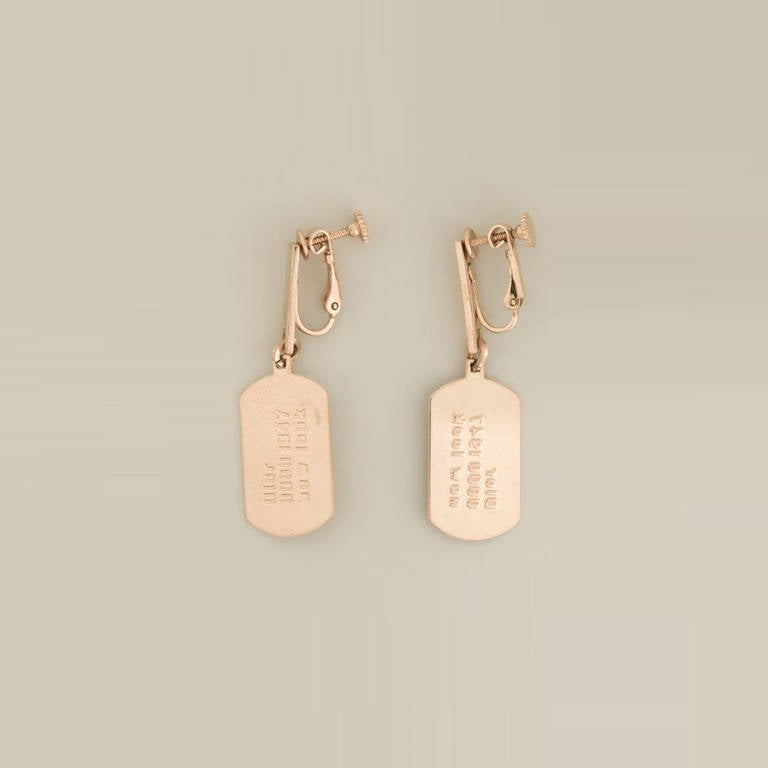 Gold-plated dog tag earrings from Christian Dior Vintage featuring a fishhook fastening and dog tag pendants.

Material: Metal

Measurements: Height: 4.5cm, Width: 1.5cm

Condition: 9 out of 10
