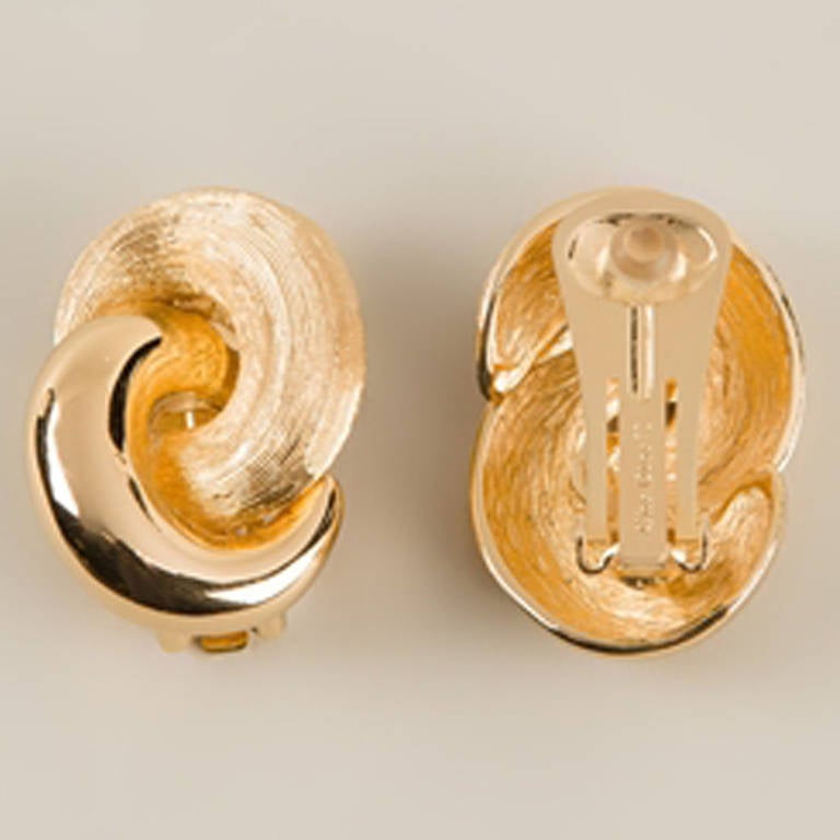 Christian Dior Vintage Wrap Loop Earrings.  	
Invest in an utterly chic edge with these gold plated metal wrap loop earrings from Christian Dior Vintage featuring a clip-on fastening. A symbol of elegance that perfectly complements any