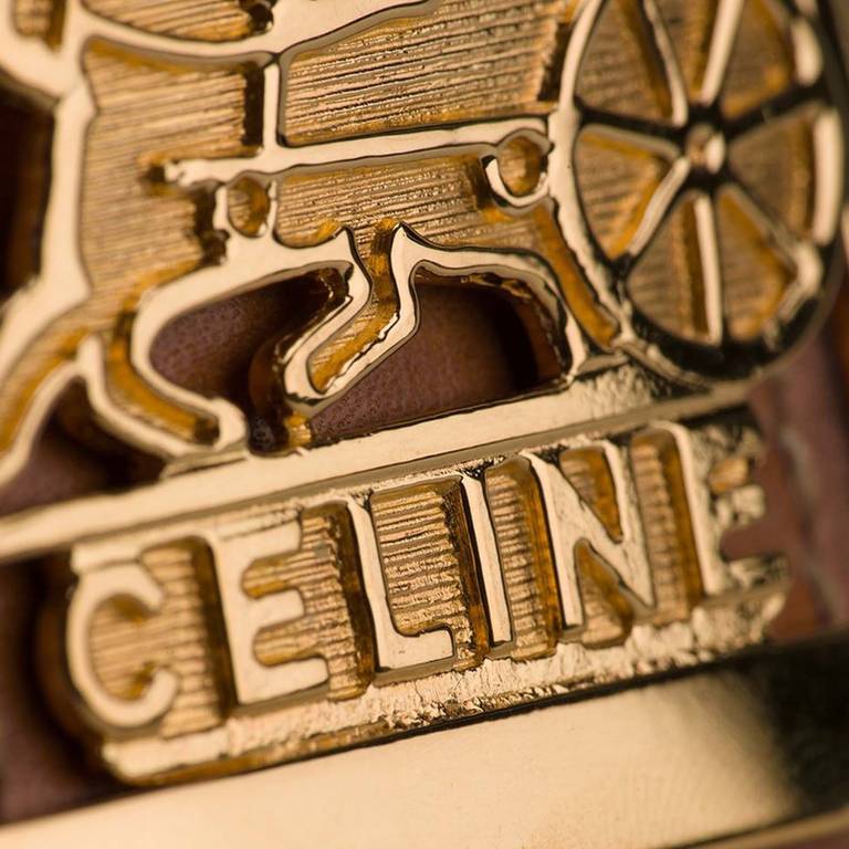 Céline Vintage Buckled Cuff Bracelet. Brown and gold-tone leather buckled cuff from Céline Vintage featuring a bracelet style strap and a signature logo buckle.

Measurements: circumference: 16 centimetres, width: 4.5 centimetres

Material: