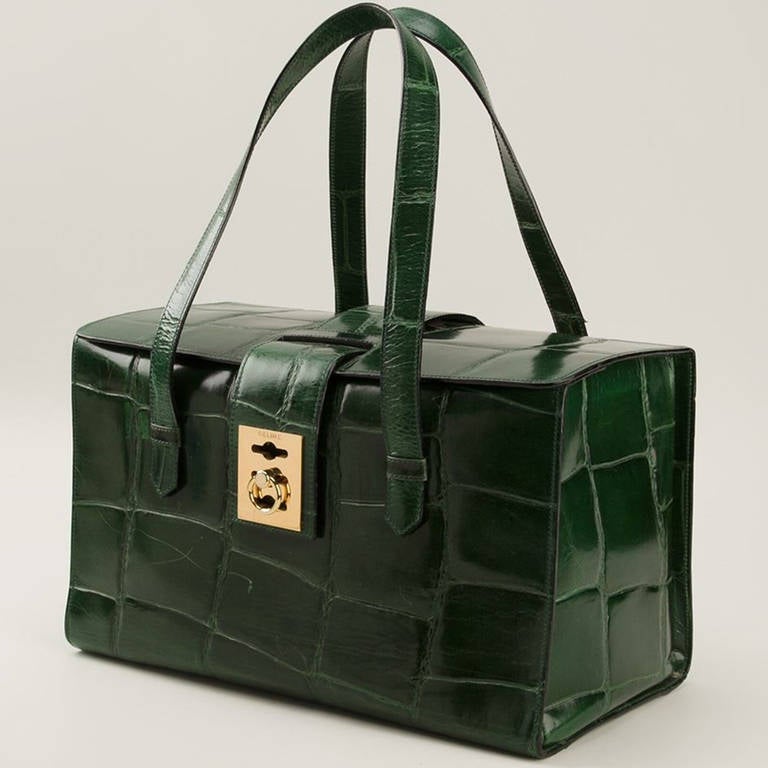 Céline Vintage Green Tote Bag. Green faux crocodile leather tote bag from Céline Vintage featuring a rectangular body, a foldover top with flip-lock closure, round top handles, an internal zipped pocket and an internal logo patch.

Measurements: