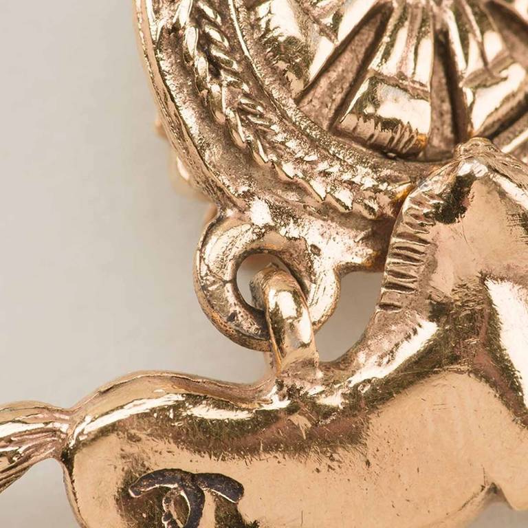 Chanel Vintage horse pendant clip on earrings. Gold plated horse pendant clip on earrings from Chanel Vintage featuring an embossed flower detail. 

Measurements:pendant width: 2.6 centimetres, length: 3.2 centimetres

Material: Gold Plated