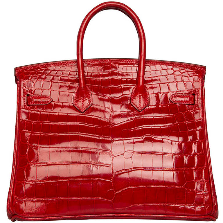 Hermes Birkin 25cm Shiny Crocodile Niloticus Lisse.  	

Make a statement with this very rare iconic Hermes Birkin bag. This petit Birkin is an incredible statement piece in red Croc Porosus with gold-Tone hardware. For its size, the leather lined