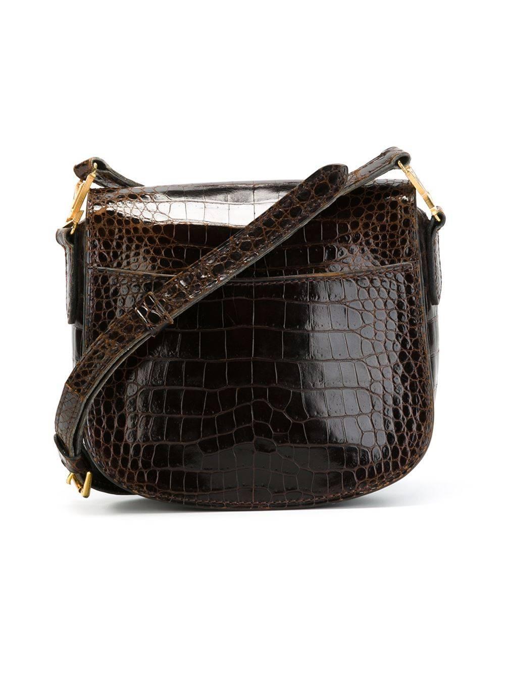 This vintage shoulder bag from Louis Vuitton features a shiny crocodile leather exterior, adjustable shoulder strap with logo detailing, gold-tone hardware, internal slit-pocket, and a snap closure.

Colour: Brown

Material: Crocodile