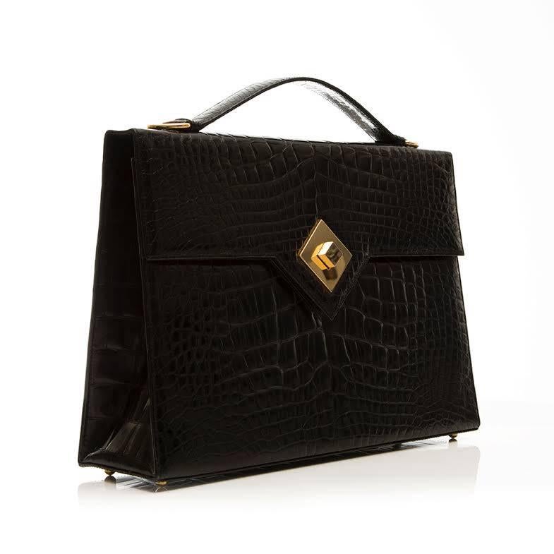 Exquisitely crafted briefcase in crocodile leather with gold tone hardware dating back to the 1950's. Featuring a black leather interior with one zipped and one open pocket. 

Colour: Black

Material: Crocodile Leather

Measurements: W: 34cm