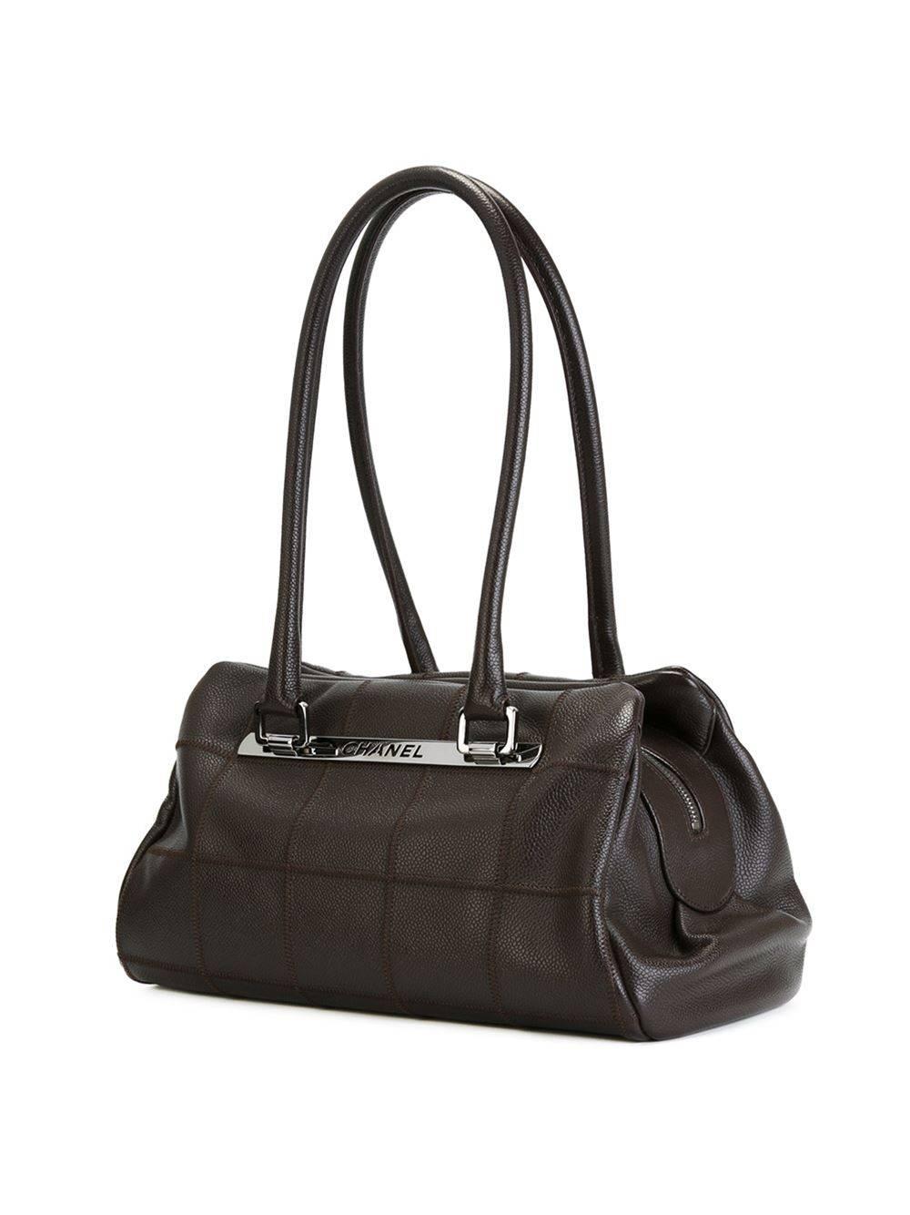 Brown leather bowling bag featuring a silver-tone logo plaque, a top zip fastening and round top handles. 

Colour: Brown

Material: Leather 100%

Measurements: W: 33cm, H: 23cm, D: 16cm, Handle: 26cm

Condition: 8 out of 10
Very Good