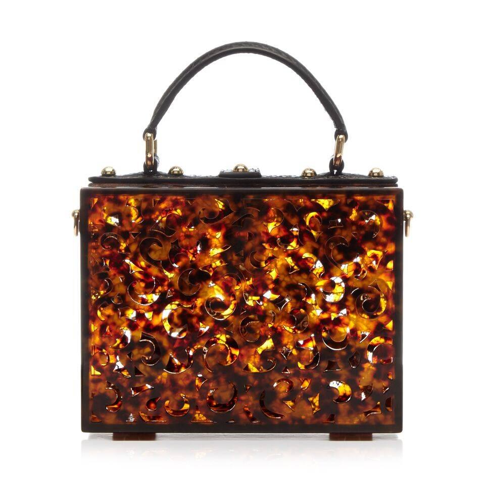 This unique Dolce & Gabbana bag exudes a classic vintage feel. The intricate design features brown plexi, red and gold enamel flowers and gold-plated hardware.

The item comes with:

Lock and Key 
Strap
Colour: Brown Plexi and Red & Gold