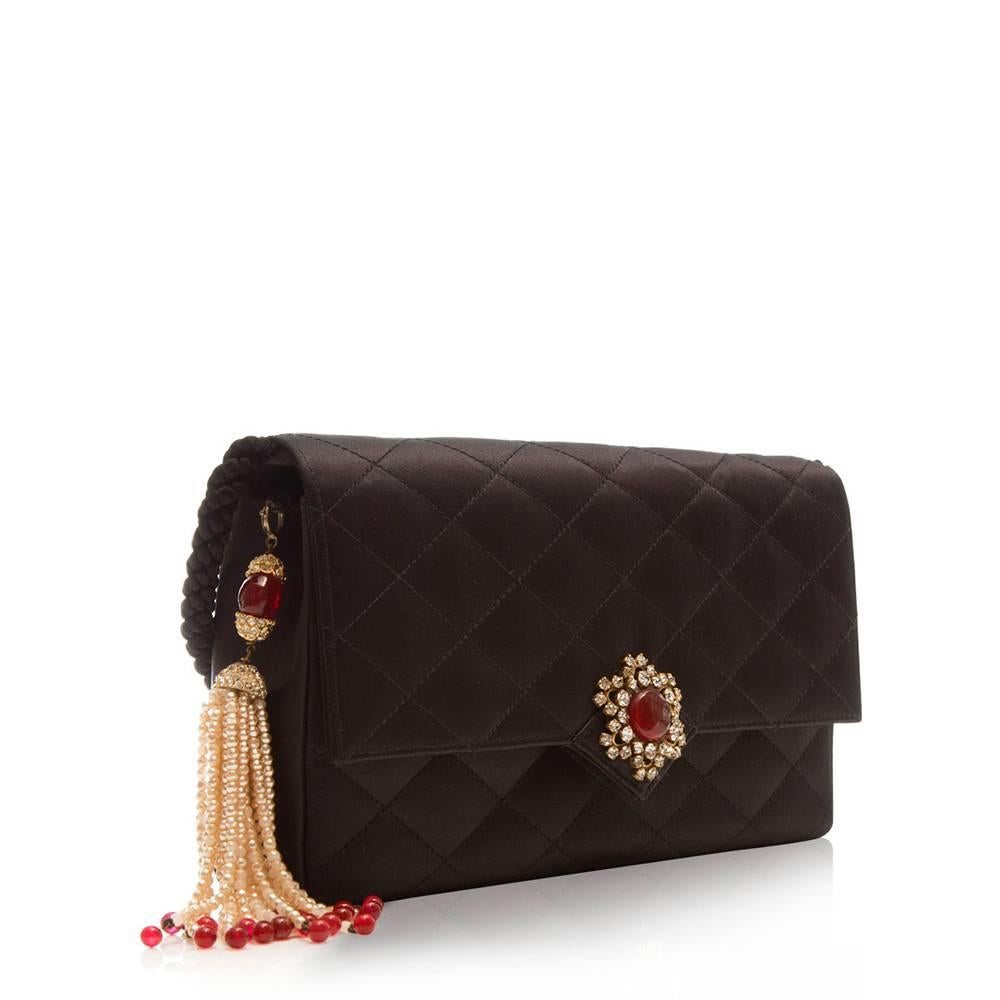 An elegant piece with a stunning gripoix on the front and faux pearls attached on the side. This beautifully crafted bag features a spacious compartment, internal pocket and a CC logo stitched on the bottom.

Colour: Black

Material: Satin

W: