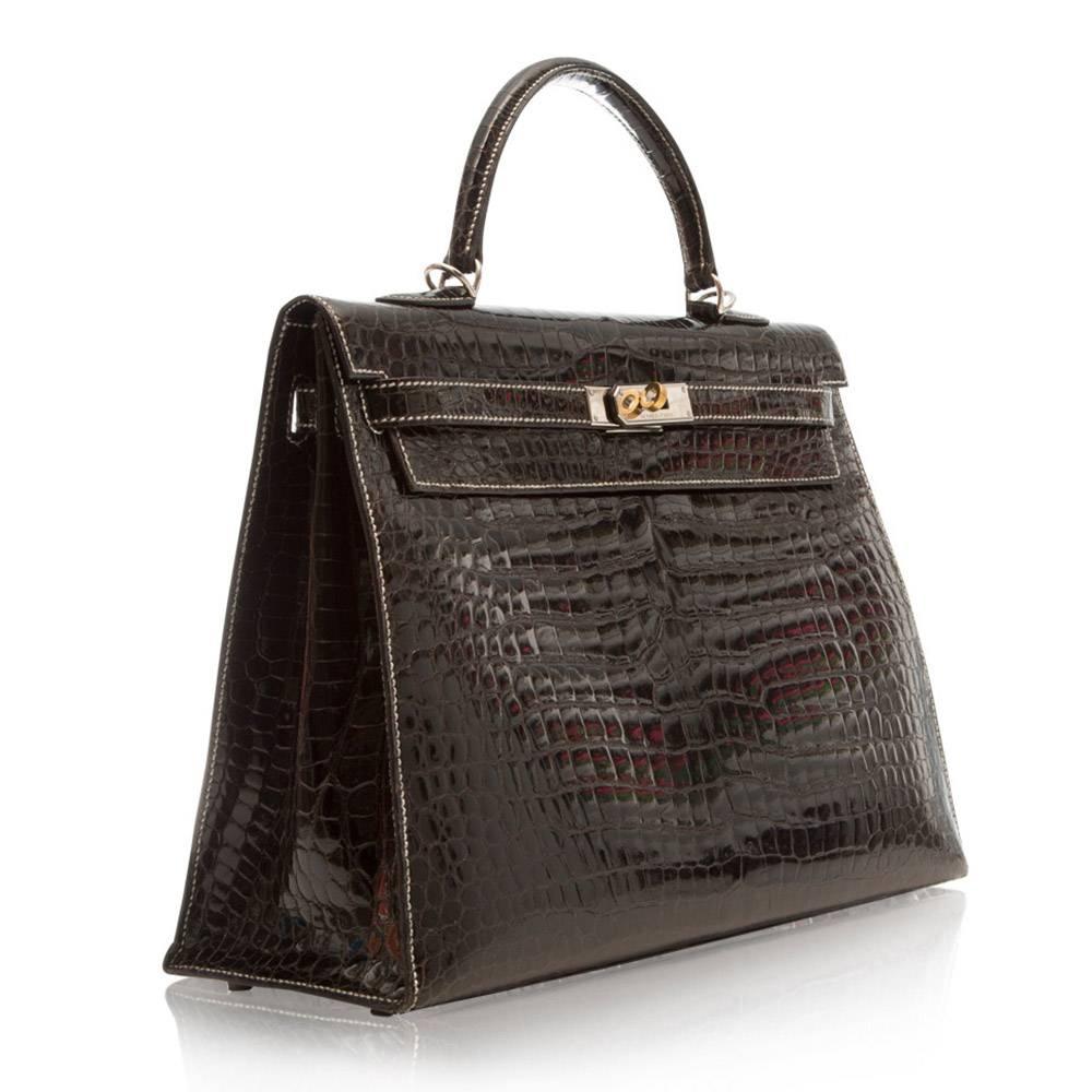 This Kelly bag from Hermes exudes classic style with crocodile porosus lisse leather combined with beautiful silver stitching detailing. The intricate design features a medium-handle, palladium hardware, internal zip-pocket, one spacious internal
