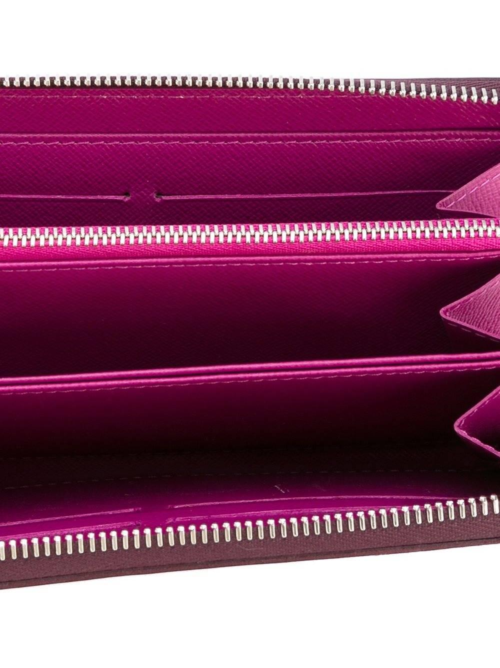 Louis Vuitton purple leather long wallet featuring an all around zip fastening, a textured leather detail, a front embossed logo stamp, multiple interior card slots, a note compartment and an interior zipped compartment. 

Colour: