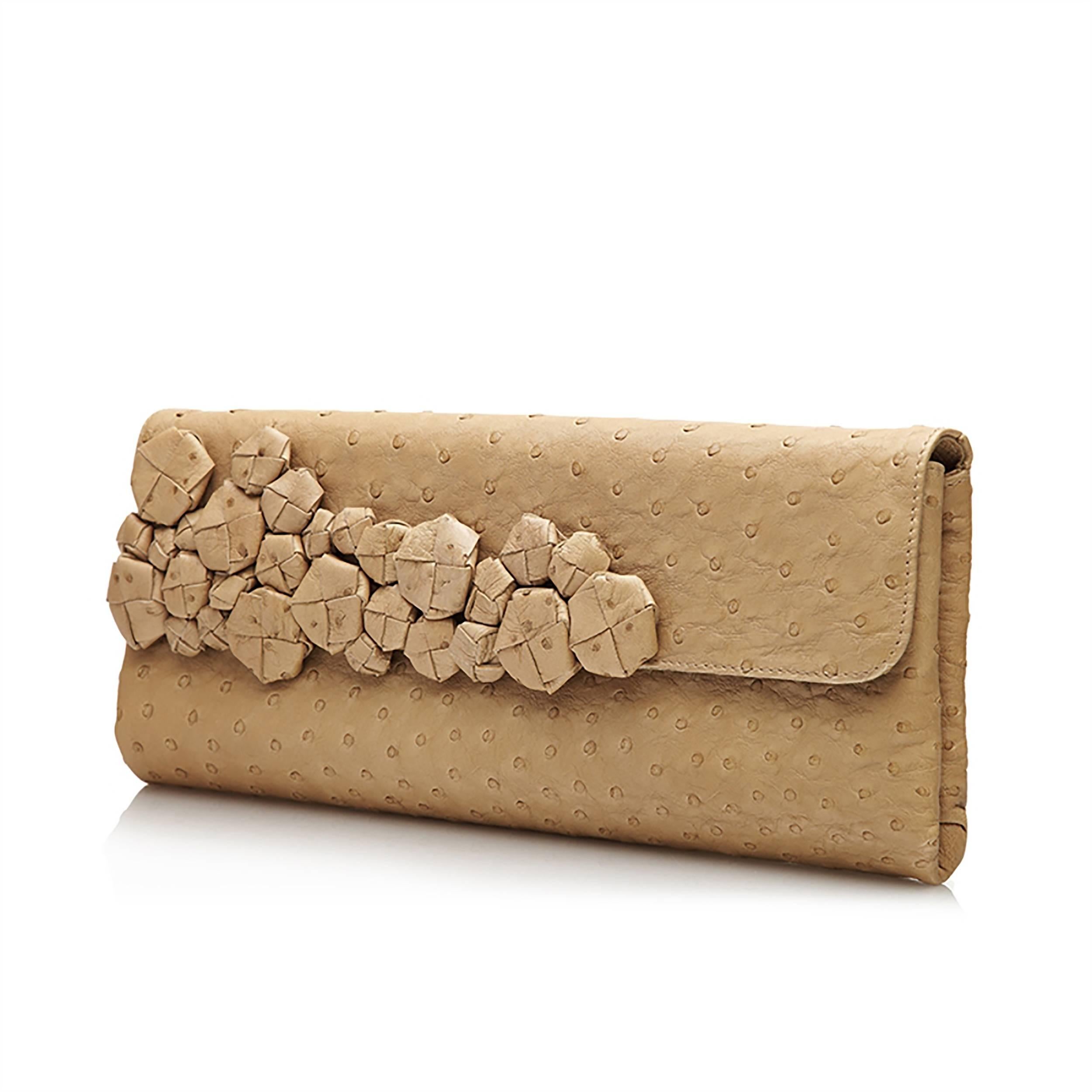 An exquisite envelope clutch by Bottega Veneta, the Italian fashion house so revered for its extraordinary quality of craftsmanship. This rare piece features a beige ostrich skin exterior. Among the most premium exotic leathers, ostrich skin is