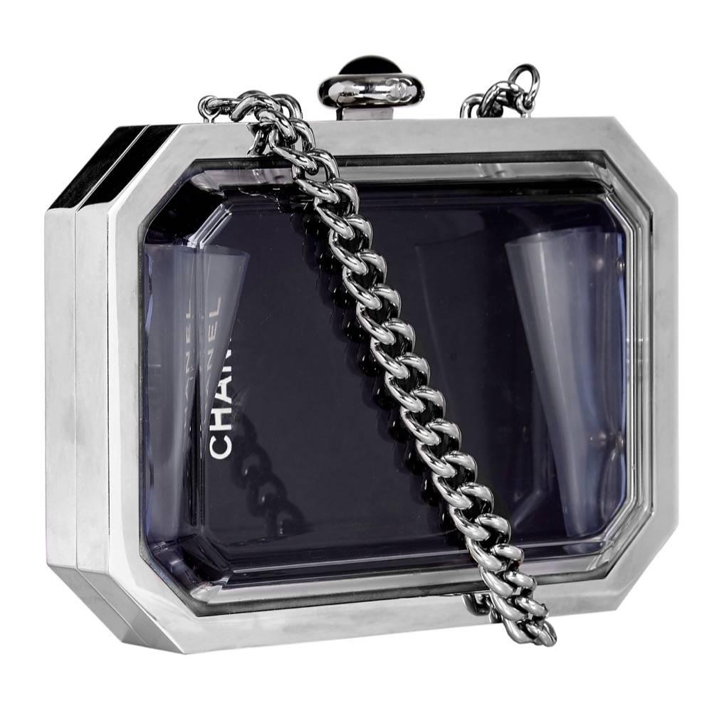 This vintage Chanel minaudière is crafted from mirrored hardware in sleek style lines. Panelled with plexiglass, one side is glossy black and the other is transparent - you can even see a Chanel logo through the window.  It's topped with a