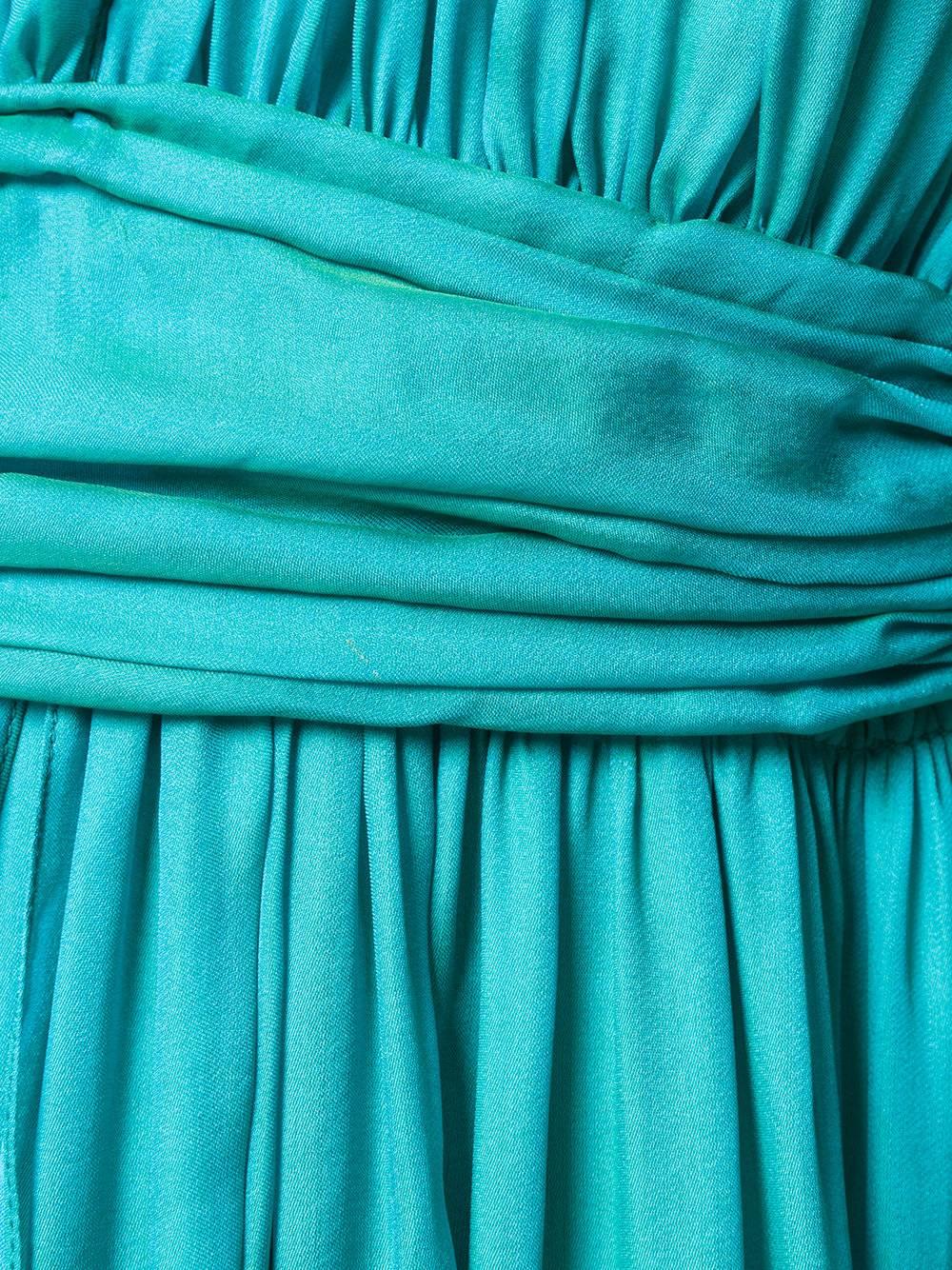 The silk-satin of this Hermès gown is quite mesmerising – its vivid turquoise hue has an iridescent green lustre that moves with the light. This dress has a V-neckline with ruching along the bodice that flows into a floor-sweeping skirt. The back is