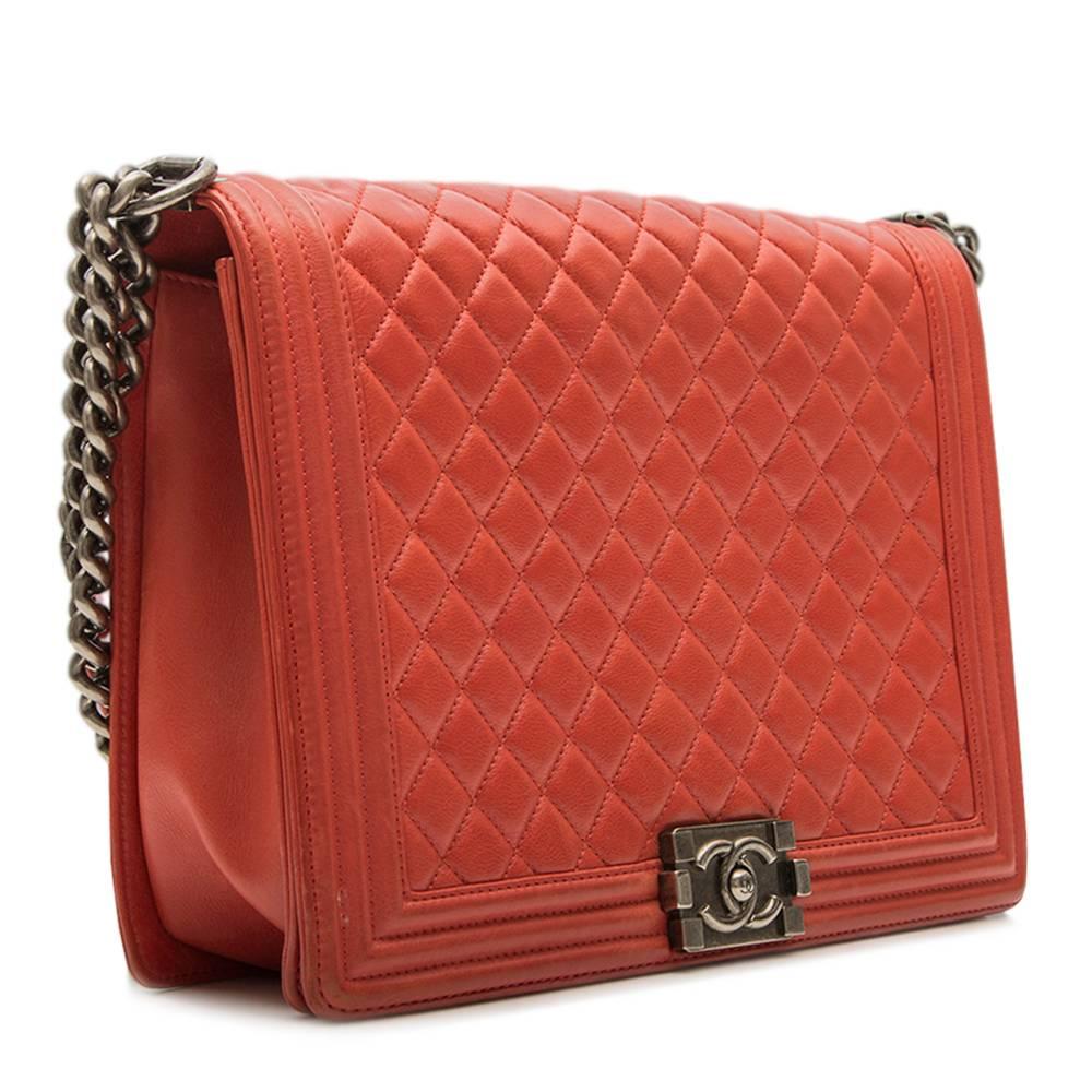 This Chanel Boy Quilted Flap Bag is crafted from a striking red quilted leather. Extremely popular, and most enviable, the Boy flap bag features an aged silver chunky chain link strap with leather shoulder pad, this is complimented by the iconic
