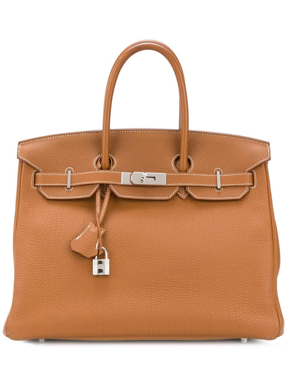 This Hermès Birkin 35cm is crafted from gold togo leather, a highly popular hide due to its ability to retain its shape and near-scratch resistance. Its deep, The gold exterior is offset with silver-toned palladium hardware. 35cm in width, the