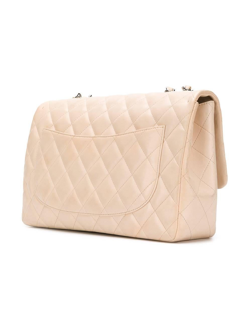Crafted from luxurious lambskin leather, this timeless Chanel flap bag features a diamond quilt finish and a versatile leather shoulder strap chain that can be worn on the shoulder or lengthened to wear with a longer drop. The main foldover top is