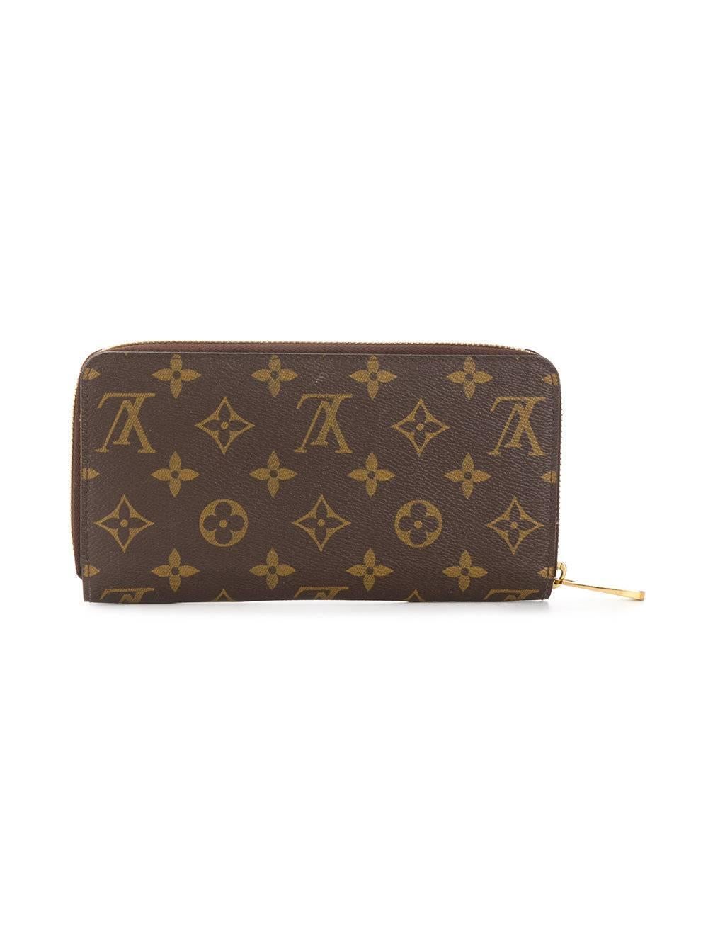 This classic monogram pattern wallet from Louis Vuitton features a zipped top accented by gold-tone hardware and opens to reveal two internal compartments, including an internal slip pocket, a coin pocket and multiple card slots.

Colour: