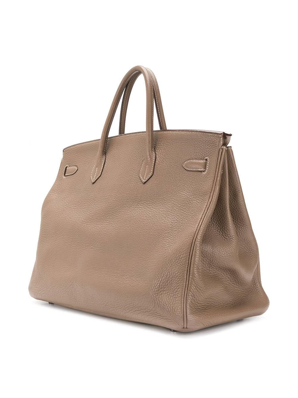 This classic Birkin 40, was fashioned from Etoupe leather and is perfect for everyday use. This spacious bag in its beige tone will compliment any outfit, it's smooth leather is soft to the touch but resistant. The bag features rounded top handles,