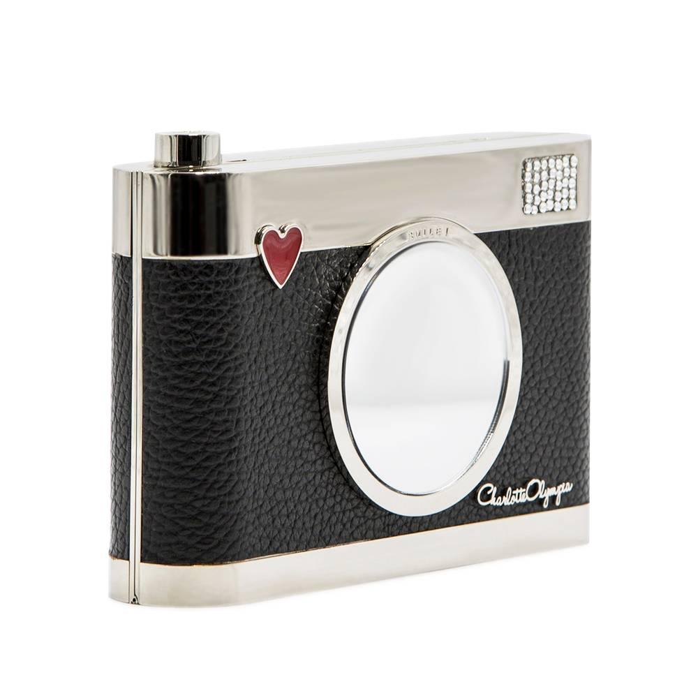 Crafted in Florence, Italy from silver-tone brass and black textured calf-leather, this highly sought after Charlotte Olympia  'Flashback' Camera clutch features Swarovski crystals and a playful 'Smile!' inscription just above the mirrored lens. The