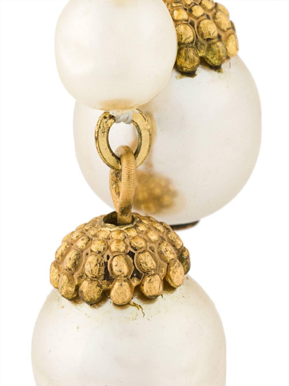 In baroque style, these vintage clip-on earrings are adorned with faux pearls in a drop silhouette.

Colour: Gold, ivory

Material: Plastic

Measurements: Length: 6cm

Condition: 8/10

This item has been gently used. 