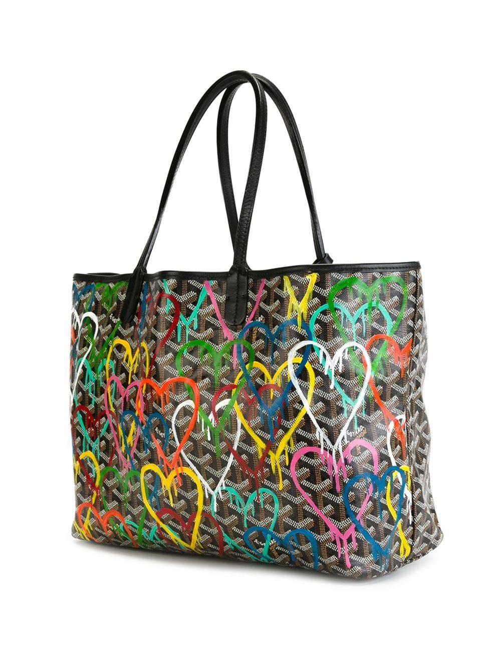 Multicoloured leather monogram shopper tote featuring top handles, a monogram print, a main internal compartment, a graffiti heart print to the front and a matching pouch.

Colour: Black/ Multi

Composition: Goyardine Canvas

Measurements: W: 47cm,