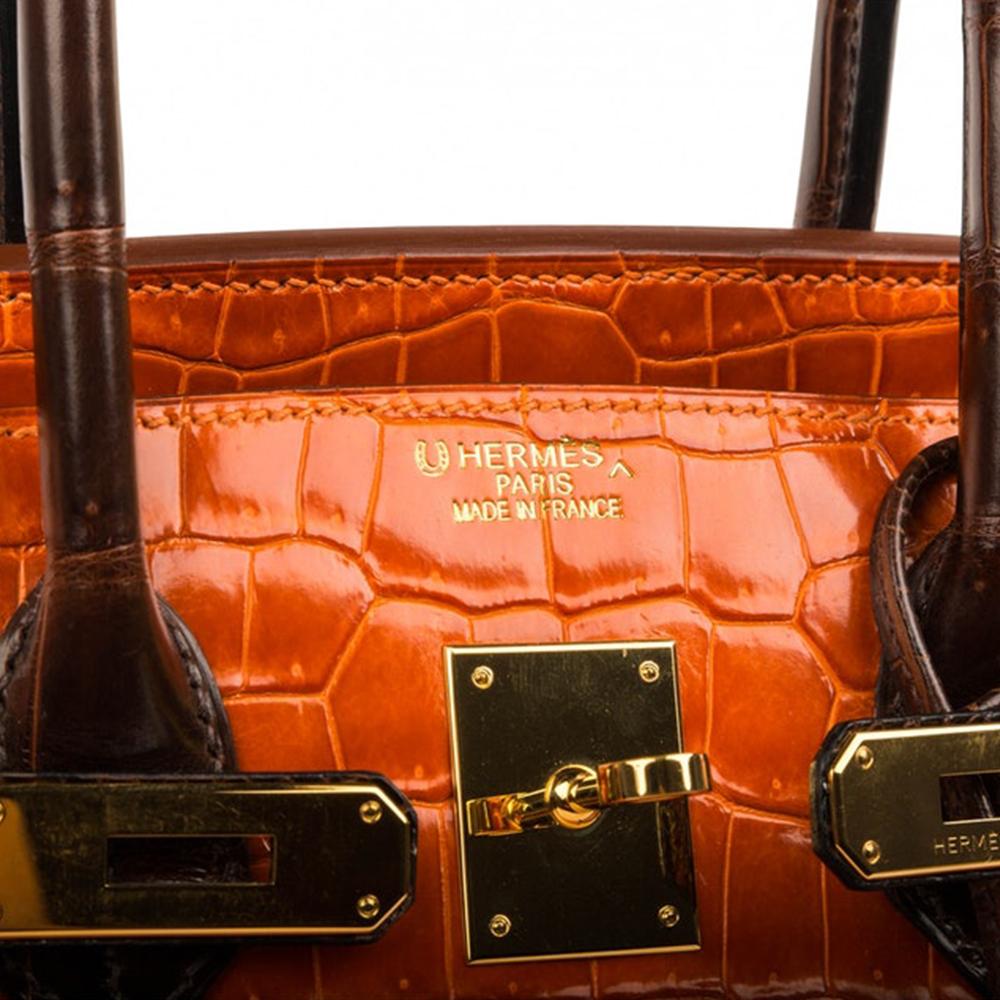 Invest in a classic with this exotic two-tone Hermes Birkin, crafted in shiny Porosus Crocodile Leather in a vibrant orange and brown contrast. Produced in 2010, the bag features two rolled leather handles, a twist lock closure accented by gold-tone