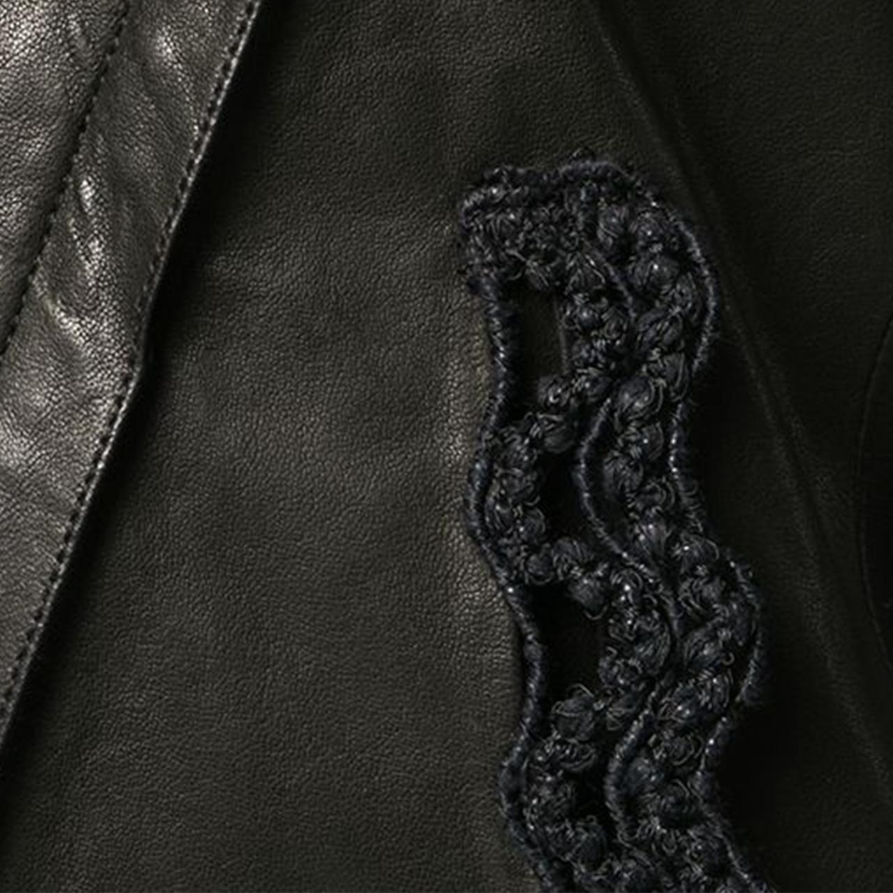 Expertly cut and crafted from smooth black lambskin and a delightful silk lining, this long sleeved biker jacket features a cropped length and the distinct, modern design of crochet trim detailing around the wide lapel. The off-centre front zip