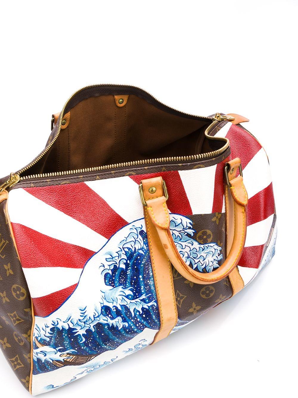 This hand-painted Louis Vuitton 'Japanese Wave' Keepall bag from Rewind's Emotional Baggage collection, where iconic handbags are specially customised with hand-painted illustrations. Crafted in Monogram Canvas leather and accented by gold-tone