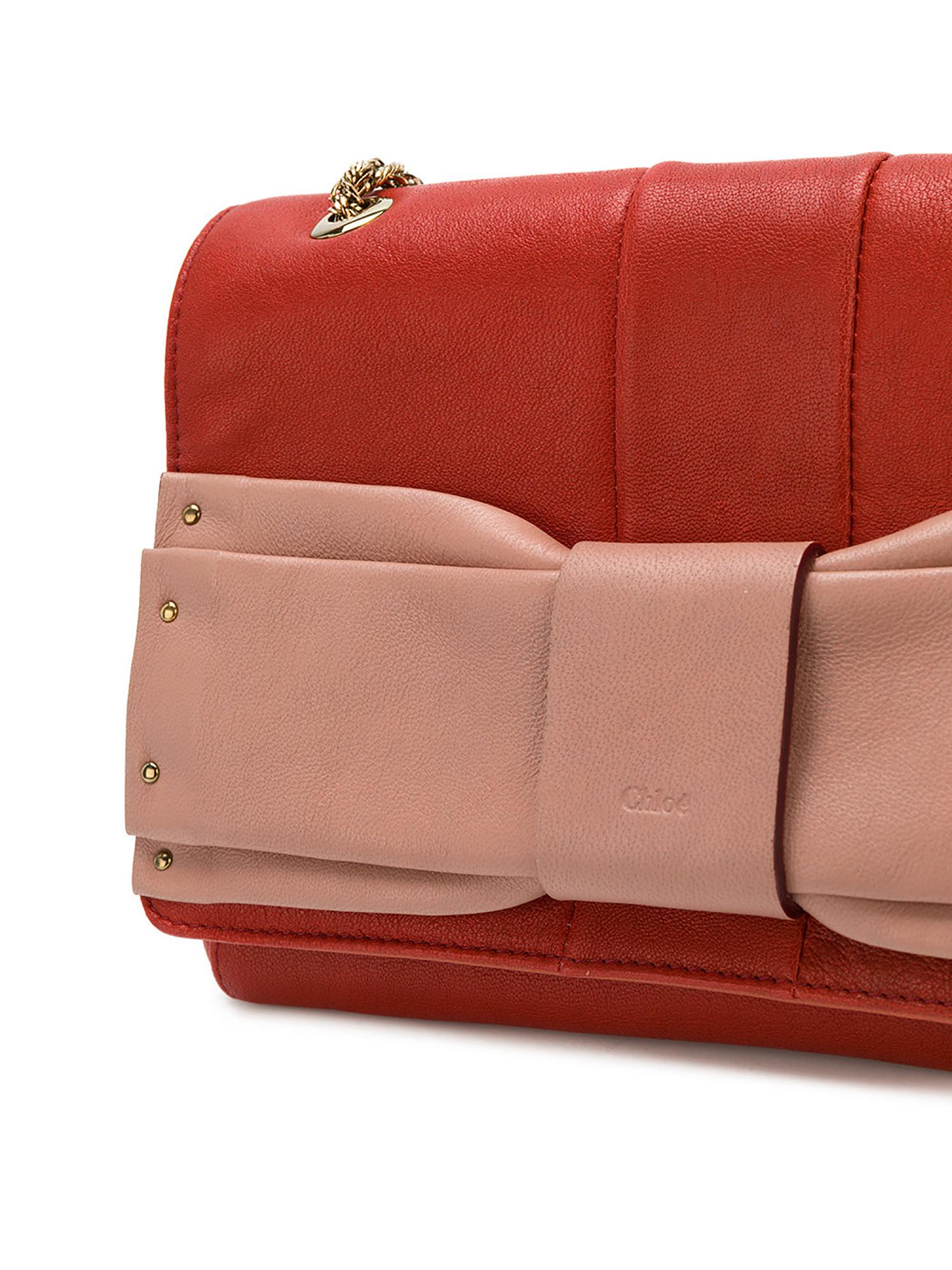 Exhibiting the playful femininity known to the Parisian brand, this Chloé June shoulder bag is crafted from leather, all finished with a logo-embossed bow. Red and pink are offset with gold-tone hardware, including a chain shoulder strap. The cream