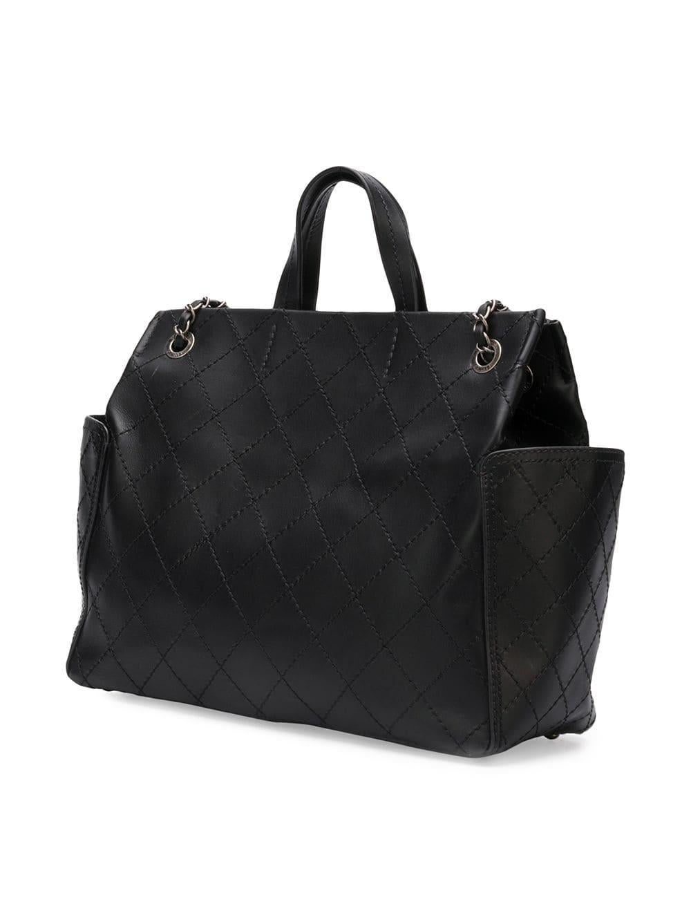 Crafted from smooth black lambskin leather, this small shopping tote bag was first introduced in the Chanel 2015 Spring Collection and features the iconic diamond-quilted design, a dangling metal interlocking CC logo accented in gunmetal-grey