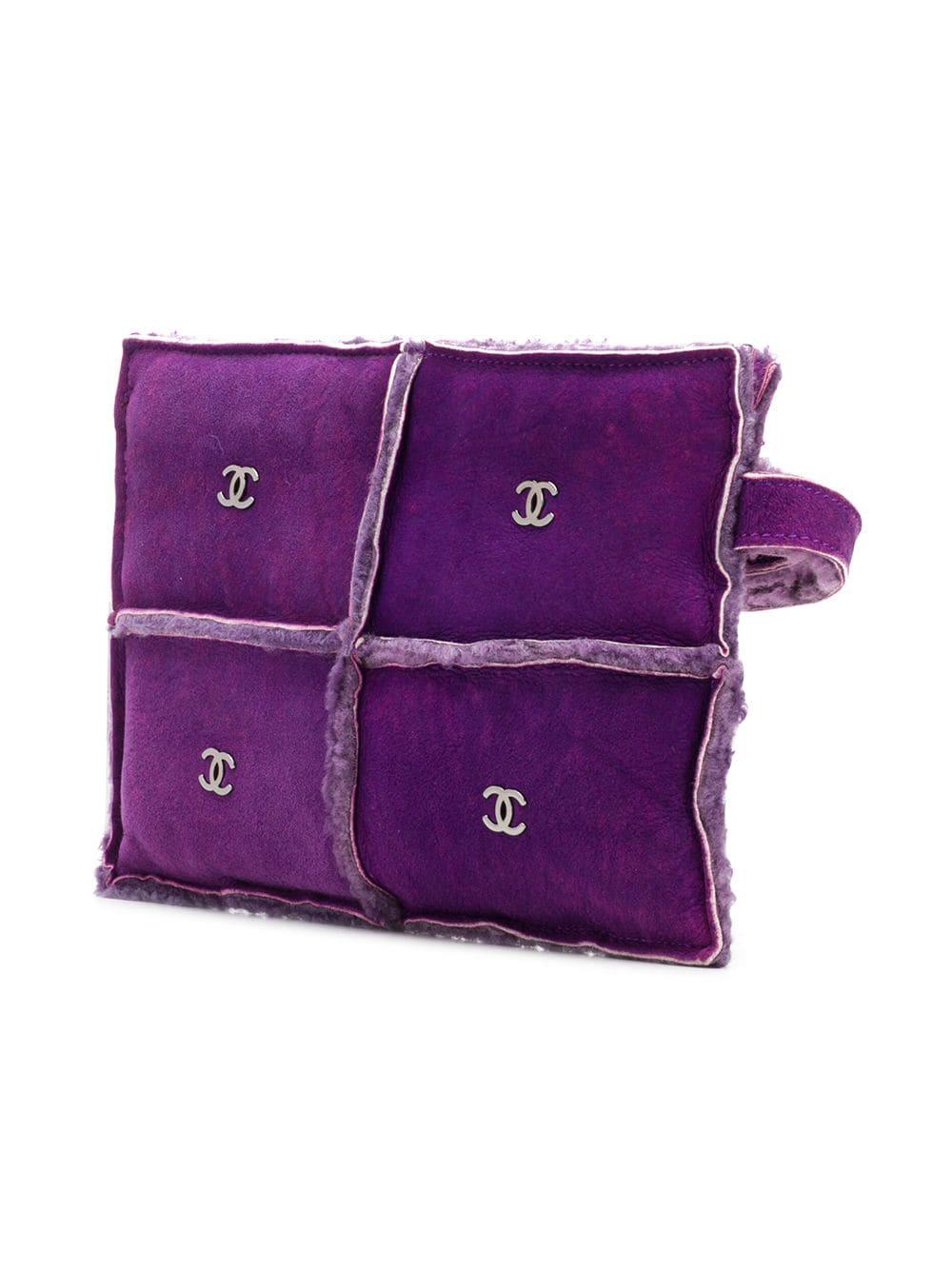 Crafted from bright purple dyed and quilted sheepskin leather with shearling fur at the seams, this stylish clutch is accented with 8 signature interlocking CC logo's in silver-tone hardware and features a looping hand strap, a top snap closure