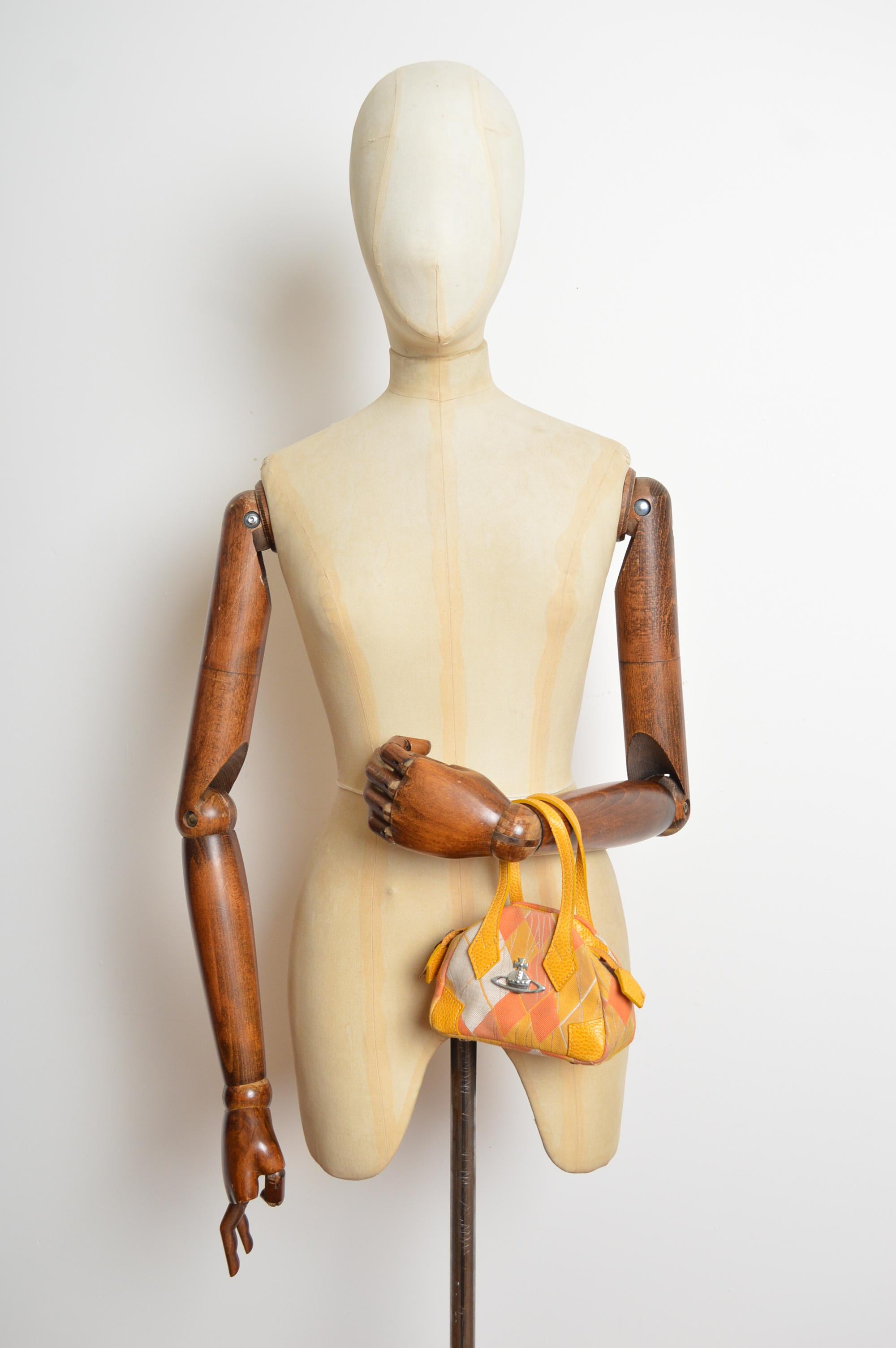  Favolosa micro borsa Vivienne Westwood dei primi anni 2000, realizzata in jacquard argyle giallo e arancione con finiture in pelle gros grain. Cerniera cromata, orbita decorativa esterna e borchie metalliche in rilievo sul fondo. Abbastanza grande