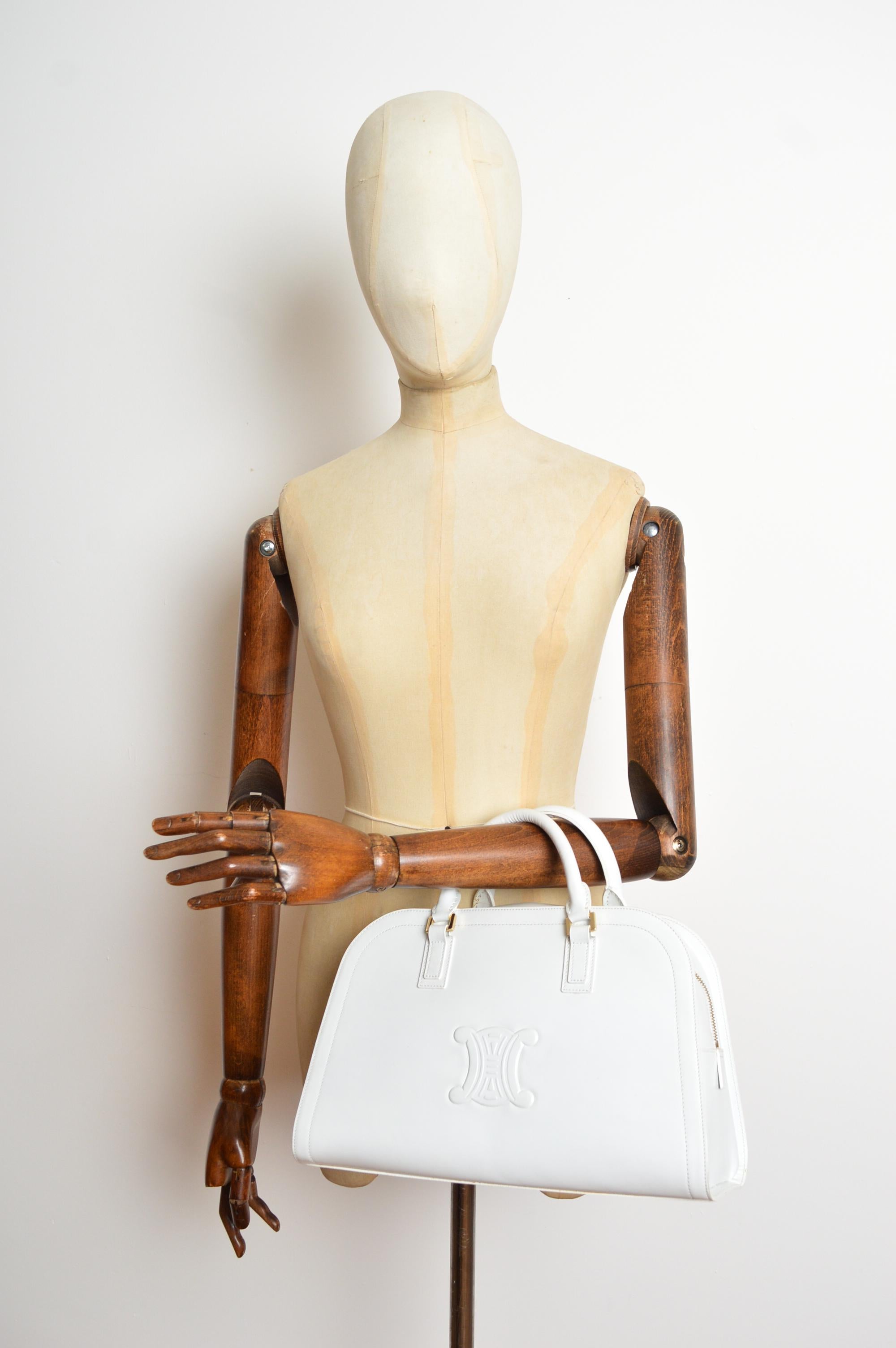 Eine große, prächtige CÉLINE Triomphe Tasche aus weißem Leder mit goldfarbenem Metallkopfschmuck. Einfacher Reißverschluss oben und zwei Griffe. Die Tasche ist mit schwarzem Celine 'CC' Jacquard gefüttert. Ausgestattet mit einem großen Hauptfach und