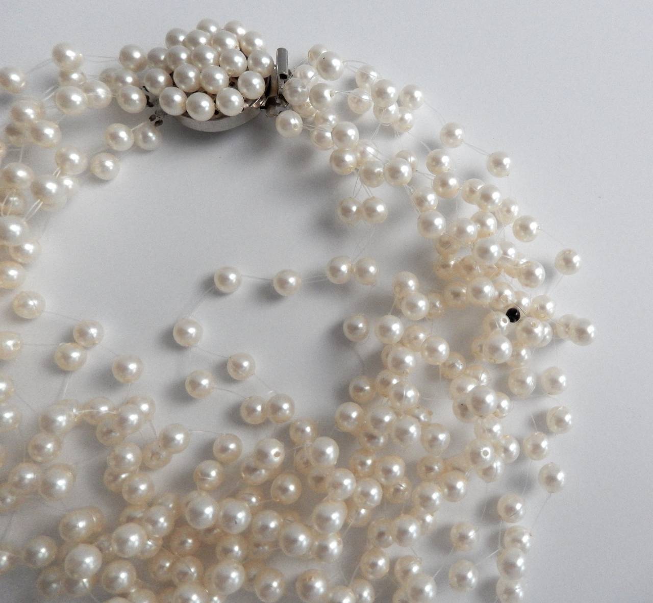 An elegant pearl necklace by Langani with her signature black bead.  In 1957 Anna Lang copyrighted her technique of stringing faux pearls on lightweight plastic cord giving the illusion that the necklace is 