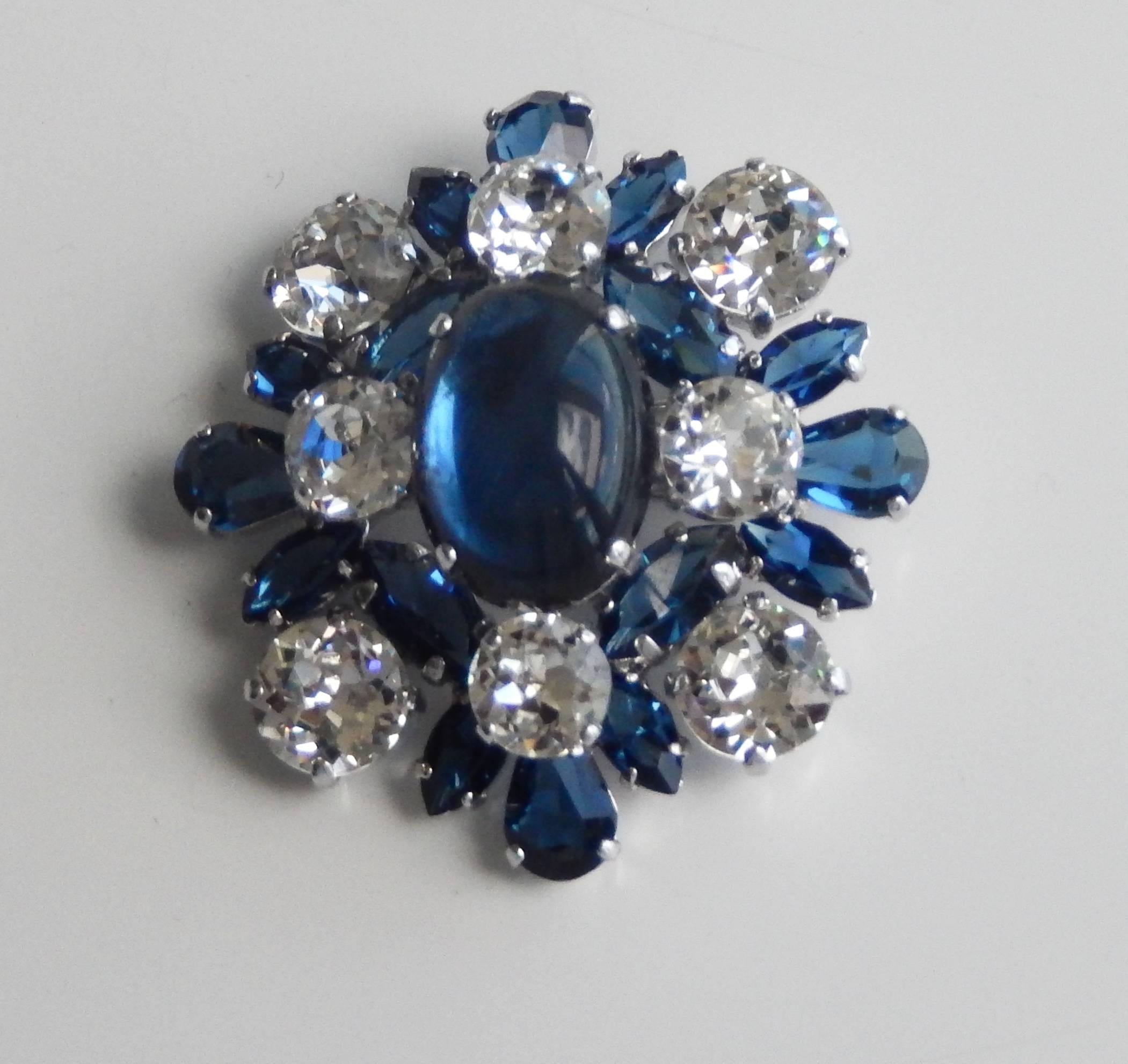 An elegant brooch by Christian Dior from the fifties. A large cabochon, faux sapphire is surrounded by faux diamonds. Dated and signed on the back of the pin.  It is rare to find Dior jewelry from this early period in such fine condition.  A