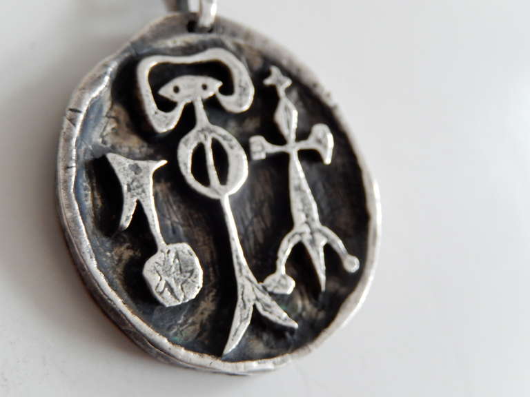 A sterling silver sculptural pendant from the 1950s by the modernist metalsmith and jeweler Ed Levin. The abstract design of tribal figures reflects his interest in non-Western cultures and imagery  Along with other Post-War American jewelers such