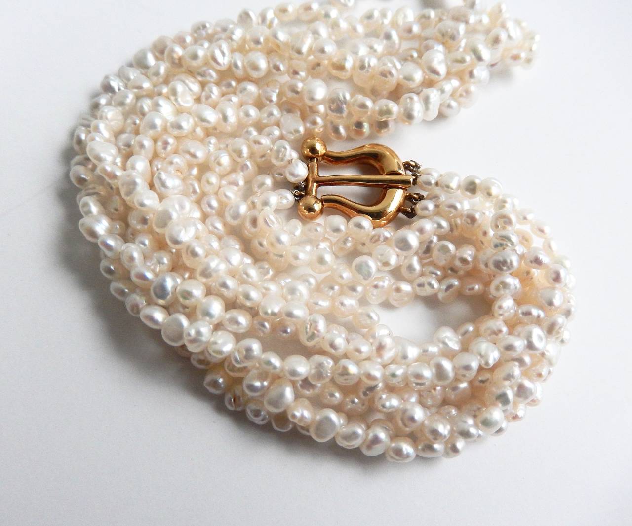 A four-strand freshwater pearl necklace with an 18K gold lyre-shaped clasp
designed in 1981 by Paloma Picasso for Tiffany & Co.  A beautiful vintage necklace by Paloma Picasso created soon after she began working with Tiffany & Co in 1980. Signed