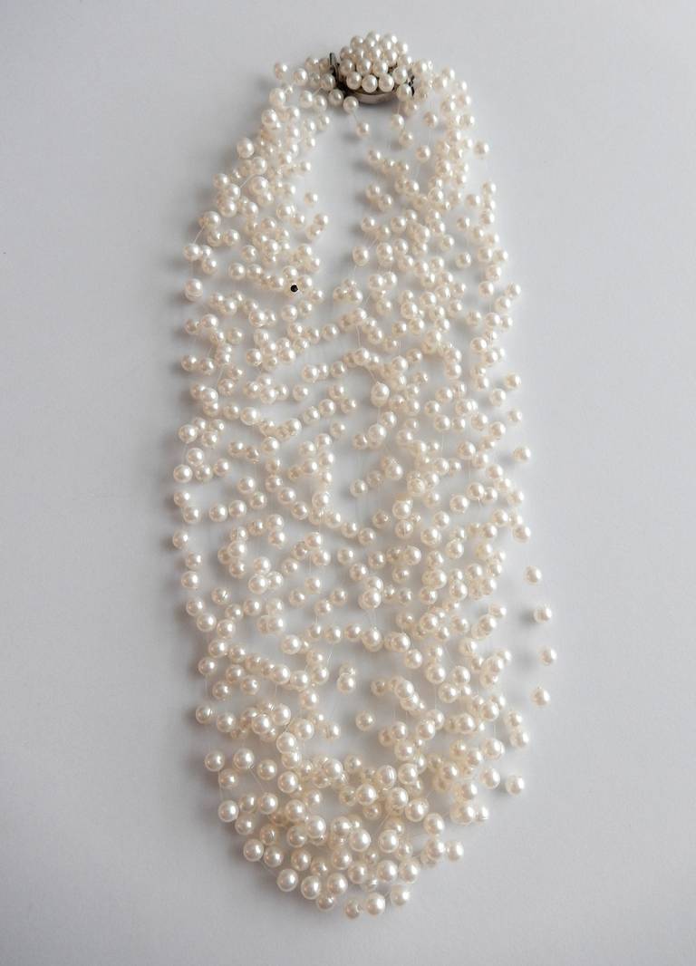 An ultra-feminine pearl necklace by Langani with her signature black bead.
In 1957 Anna Lang copyrighted her technique of stringing faux pearls on lightweight plastic cord giving the illusion that the necklace is 