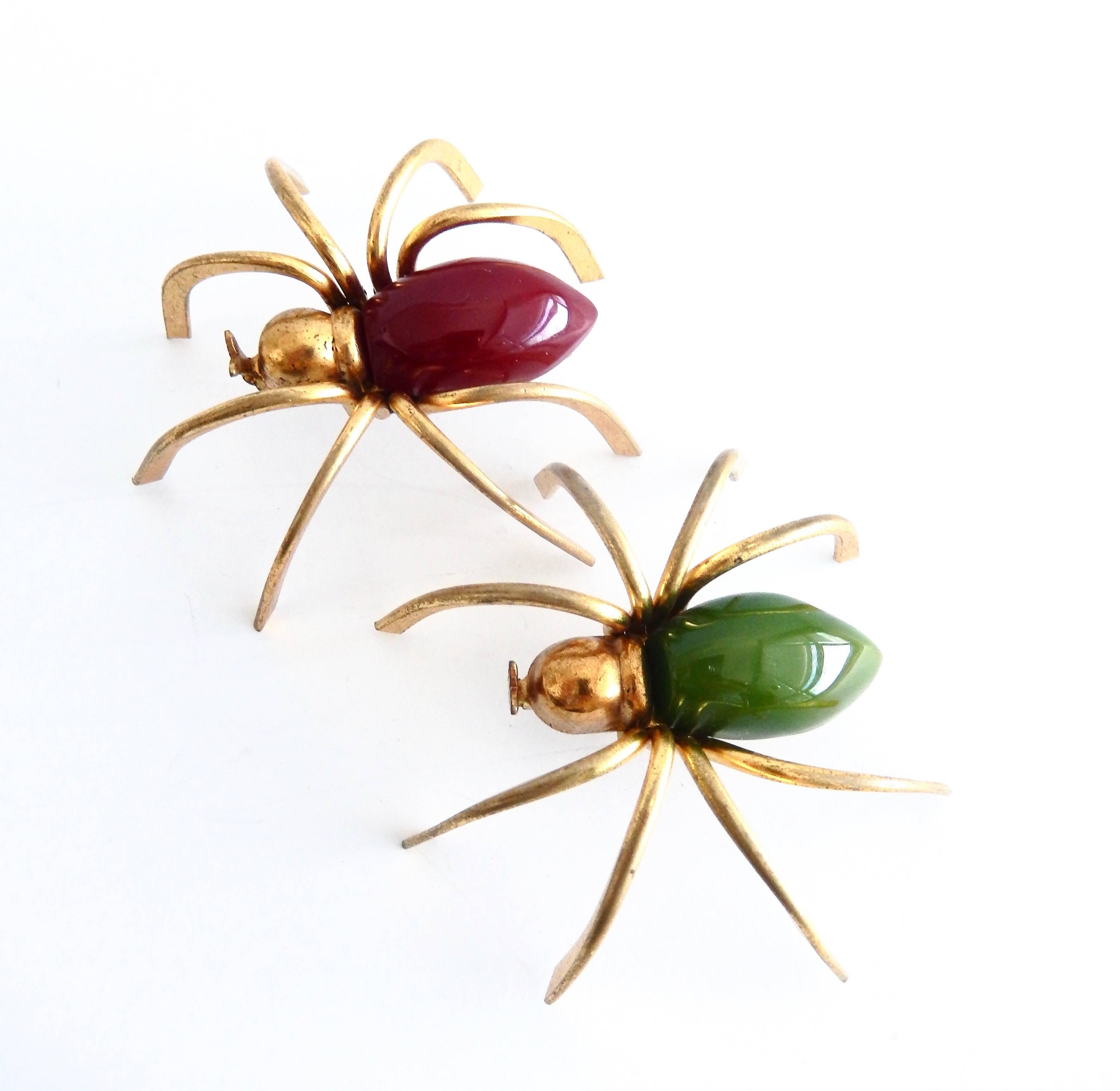 A captivating three-dimensional gilt metal spider pin with red bakelite body from the 1930s. In exceptionally good condition and a fine example of American Art Deco jewelry.   Will be a big hit at your next holiday party.

Note - Image shows 2 pins,